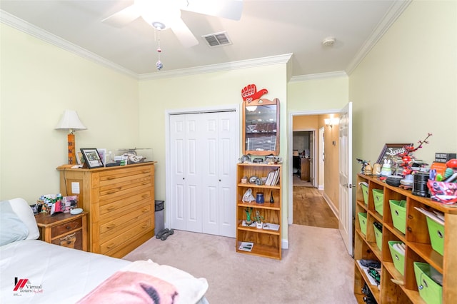 bedroom with visible vents, a ceiling fan, a closet, crown molding, and light colored carpet