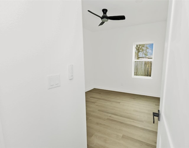 empty room with baseboards, a ceiling fan, and wood finished floors