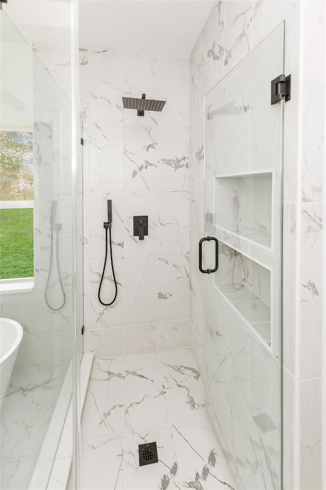 full bath featuring a soaking tub, a marble finish shower, and marble finish floor