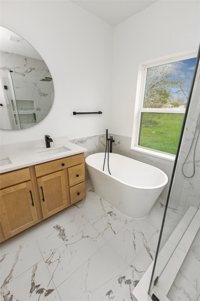 full bathroom with double vanity, marble finish floor, a marble finish shower, and a sink