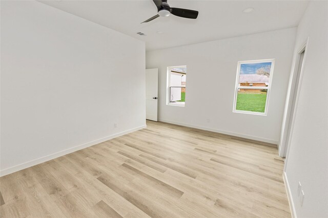 empty room featuring ceiling fan, baseboards, visible vents, and light wood-style flooring