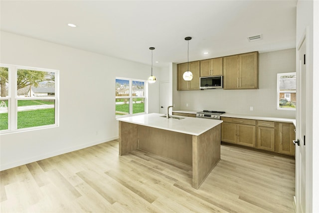 kitchen featuring light wood finished floors, visible vents, appliances with stainless steel finishes, and a sink