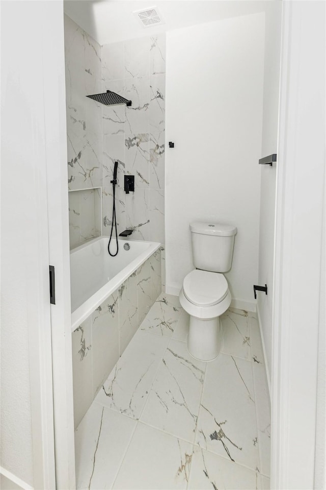 bathroom with marble finish floor, visible vents, toilet, baseboards, and tiled shower / bath combo