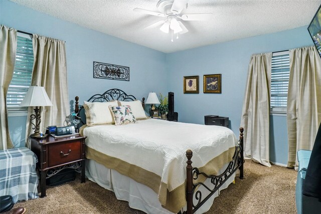 carpeted bedroom featuring ceiling fan, multiple windows, and a textured ceiling