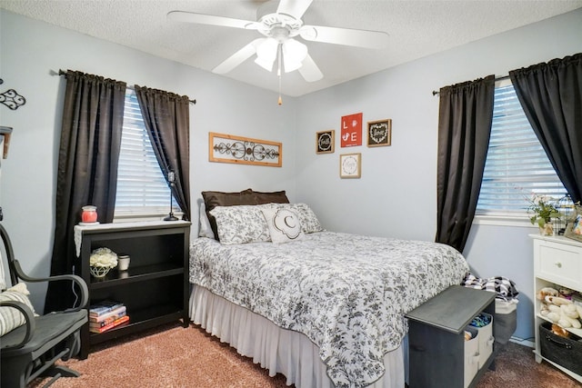 carpeted bedroom featuring a ceiling fan and a textured ceiling