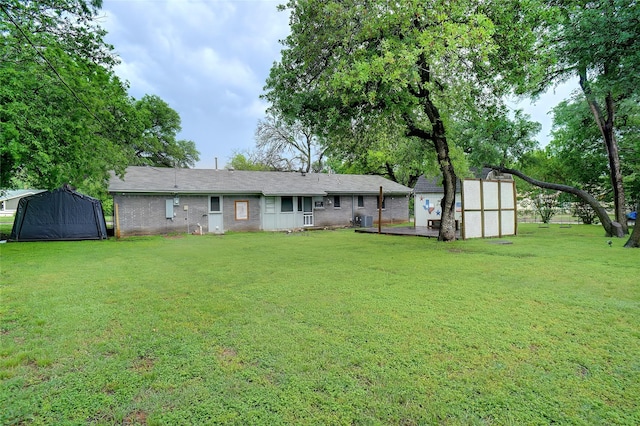 rear view of house featuring a lawn, an outbuilding, and a shed