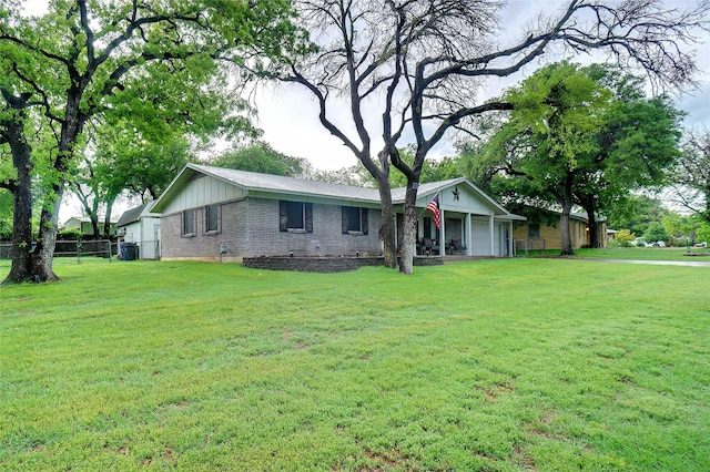 ranch-style house featuring brick siding, board and batten siding, fence, and a front yard