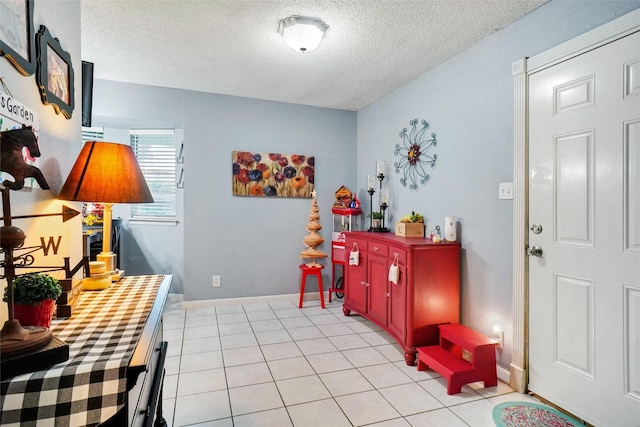 interior space with baseboards, a textured ceiling, and light tile patterned floors