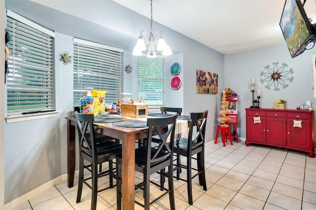 dining room featuring baseboards, a notable chandelier, and light tile patterned floors