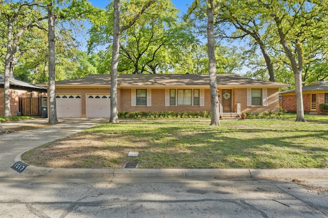 single story home with an attached garage, brick siding, a front yard, and concrete driveway