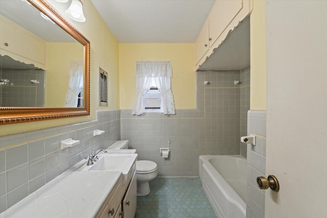 full bath featuring shower / bathing tub combination, tile walls, vanity, tile patterned floors, and toilet