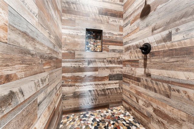 bathroom featuring wood walls and a tile shower