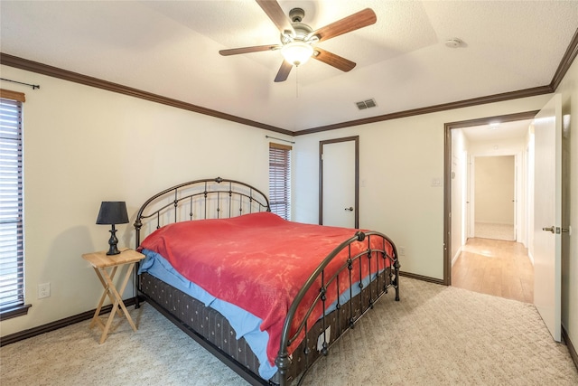 bedroom with crown molding, visible vents, carpet flooring, and baseboards