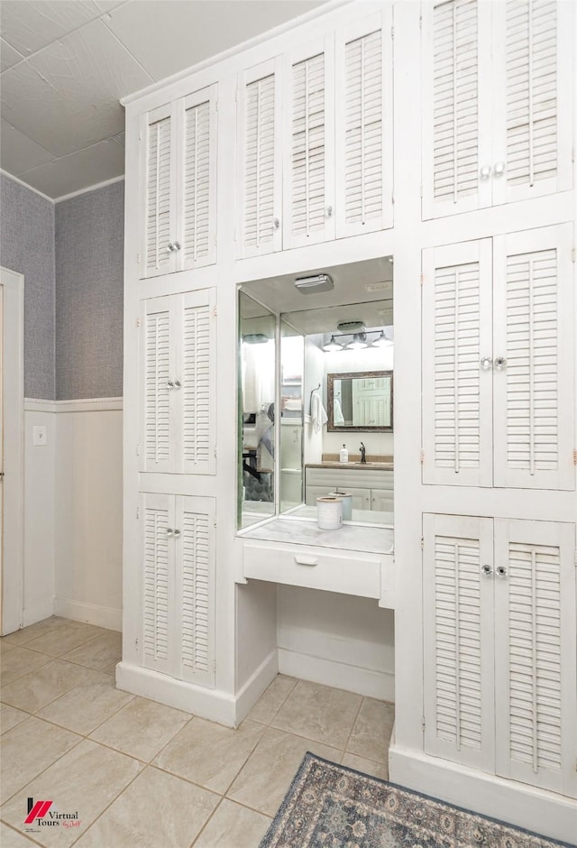 interior space with tile patterned floors and a wainscoted wall