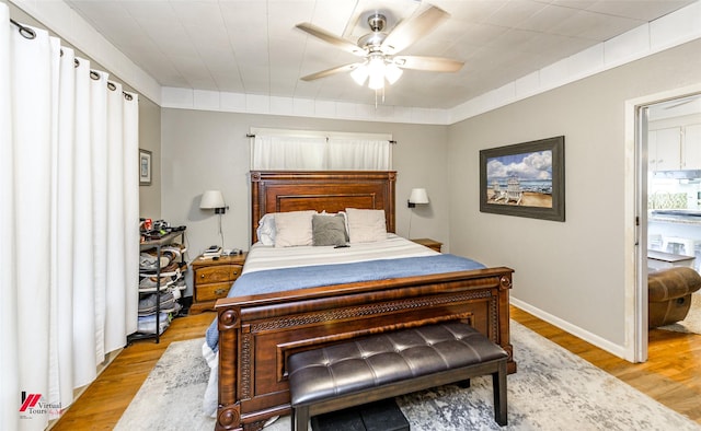 bedroom featuring light wood-type flooring, baseboards, and ceiling fan