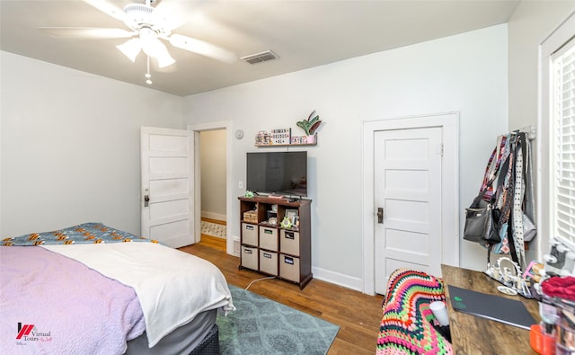 bedroom featuring wood finished floors, visible vents, a ceiling fan, and baseboards
