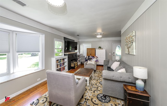 living room featuring a wealth of natural light, wood finished floors, visible vents, and baseboards