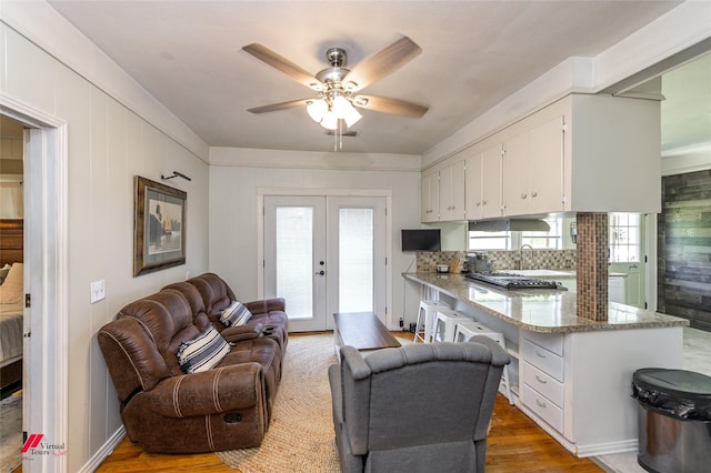living area featuring french doors, wood finished floors, and a ceiling fan