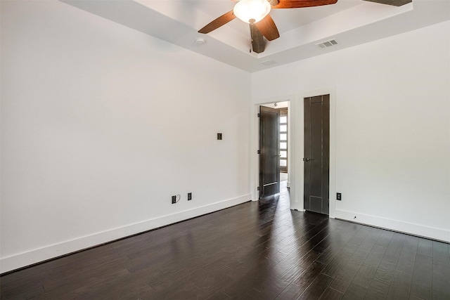 unfurnished room with baseboards, a ceiling fan, visible vents, and a raised ceiling