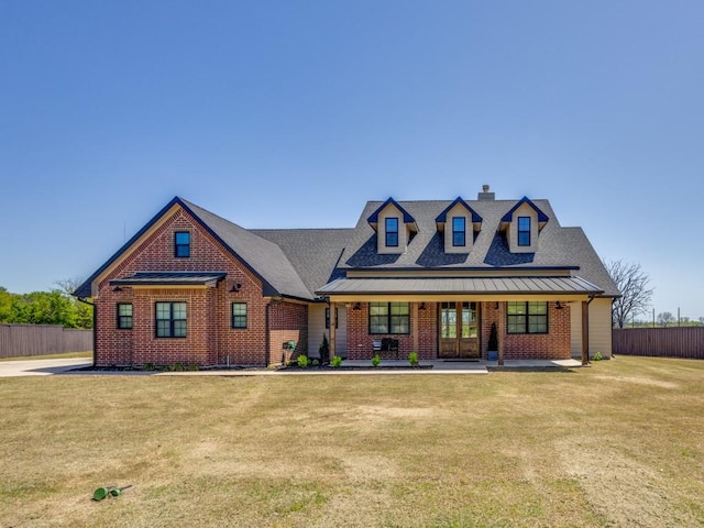 view of front of house featuring a chimney, a shingled roof, fence, a front yard, and brick siding