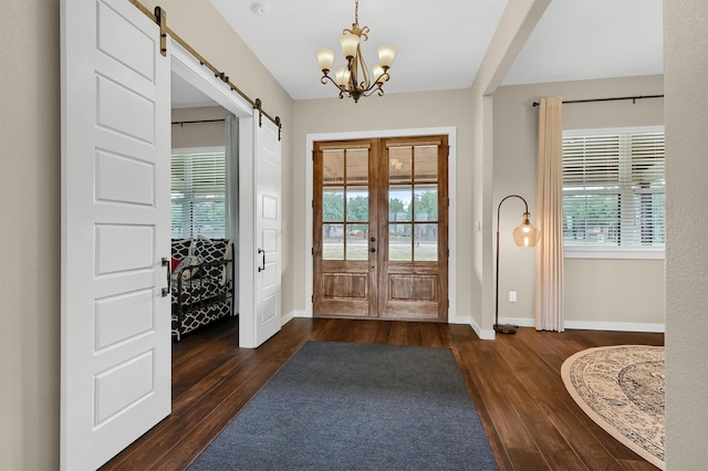 entryway with plenty of natural light, wood finished floors, and a barn door
