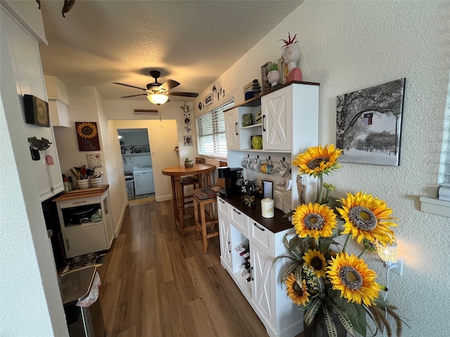 108 E Neely Ave, Comanche, TX 76442 - kitchen featuring white cabinets, dark countertops, a ceiling fan, dark wood-type flooring, and a textured ceiling