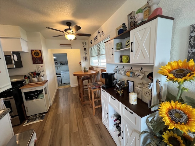 108 E Neely Ave, Comanche, TX 76442 - kitchen featuring white cabinets, open shelves, wood finished floors, and appliances with stainless steel finishes