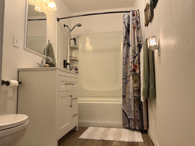 108 E Neely Ave, Comanche, TX 76442 - bathroom featuring wood finished floors, vanity, a textured wall, shower / tub combo, and toilet