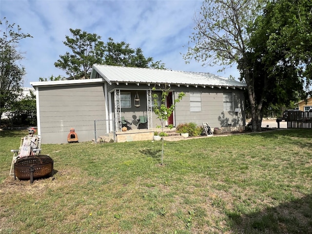 108 E Neely Ave, Comanche, TX 76442 - exterior space featuring a fire pit, a lawn, and metal roof