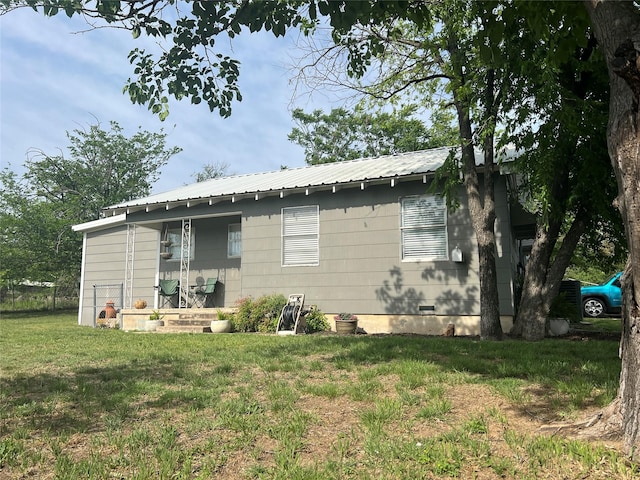 108 E Neely Ave, Comanche, TX 76442 - rear view of property featuring a lawn, crawl space, and metal roof