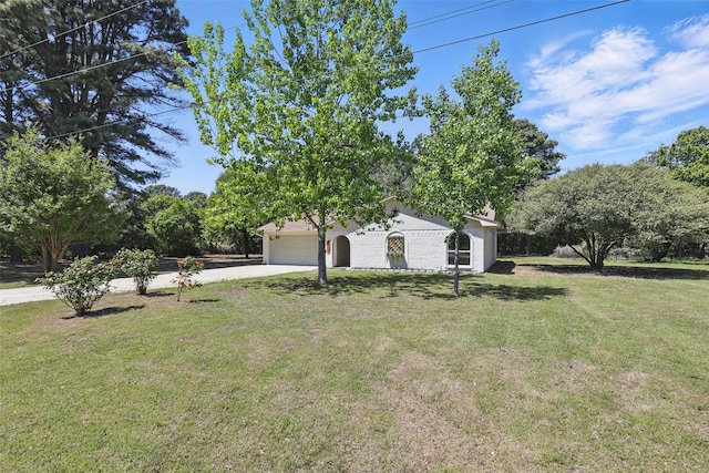 exterior space featuring concrete driveway, a yard, and a garage