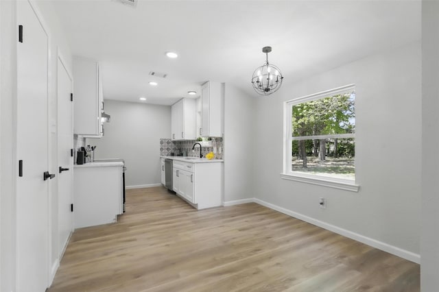 kitchen featuring light countertops, a sink, visible vents, a chandelier, and dishwasher