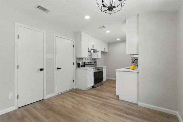 kitchen with stainless steel range with electric cooktop, visible vents, light wood finished floors, and under cabinet range hood