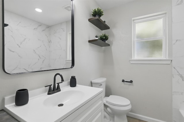 bathroom with visible vents, vanity, and toilet