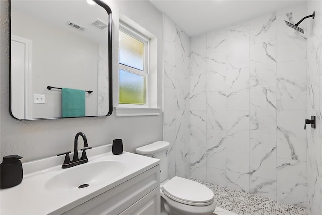 full bathroom with visible vents, toilet, vanity, and a marble finish shower