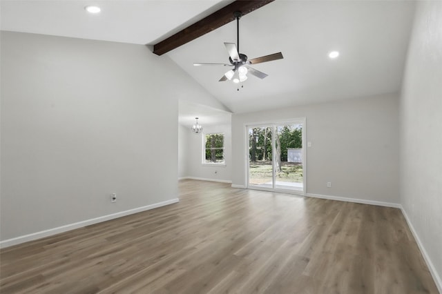 unfurnished room with ceiling fan with notable chandelier, wood finished floors, baseboards, and beam ceiling