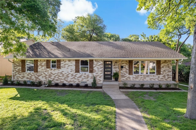 ranch-style house featuring brick siding, roof with shingles, and a front yard