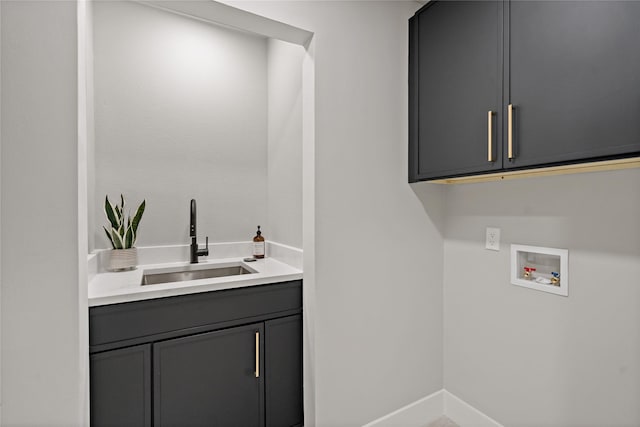 washroom with cabinet space, washer hookup, baseboards, and a sink