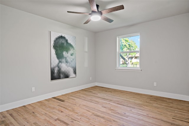 spare room with ceiling fan, baseboards, and light wood-type flooring