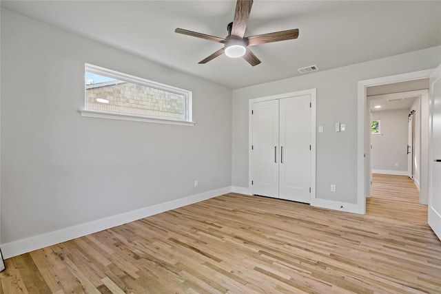 unfurnished bedroom with a closet, light wood-style flooring, visible vents, and baseboards