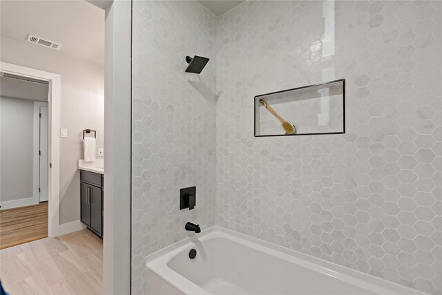 bathroom with baseboards, shower / bathtub combination, visible vents, and vanity