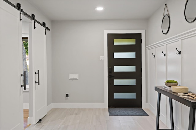 mudroom featuring baseboards, recessed lighting, and a barn door