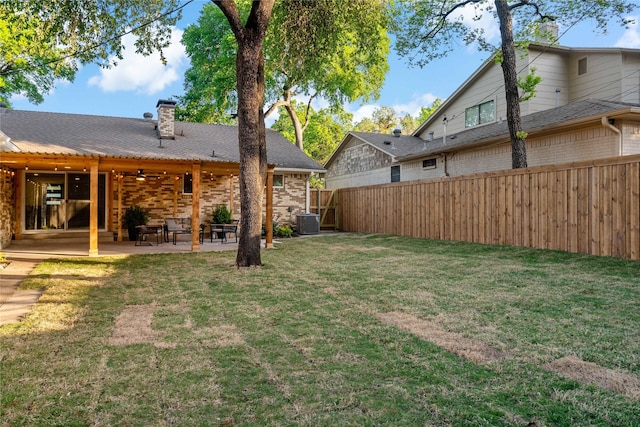 view of yard featuring a fenced backyard, a patio area, a ceiling fan, and central AC