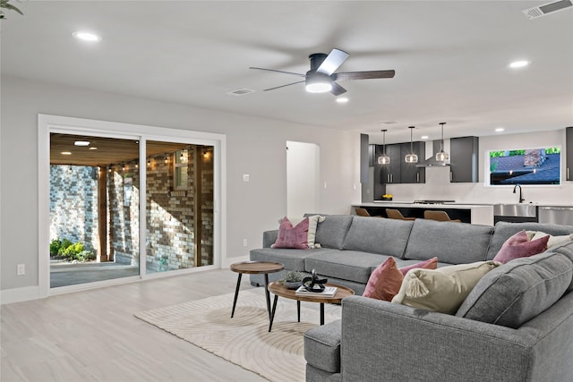 living room featuring baseboards, a ceiling fan, visible vents, and recessed lighting