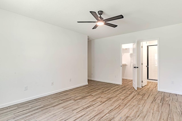spare room with light wood finished floors, baseboards, and ceiling fan
