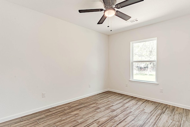 unfurnished room featuring baseboards, a ceiling fan, light wood finished floors, and visible vents