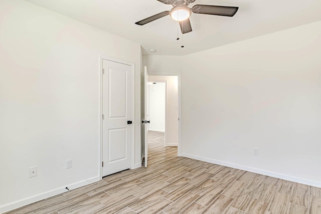 spare room featuring baseboards, light wood-style floors, and ceiling fan
