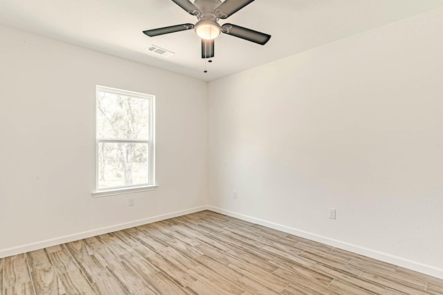 empty room with baseboards, visible vents, and light wood-style flooring