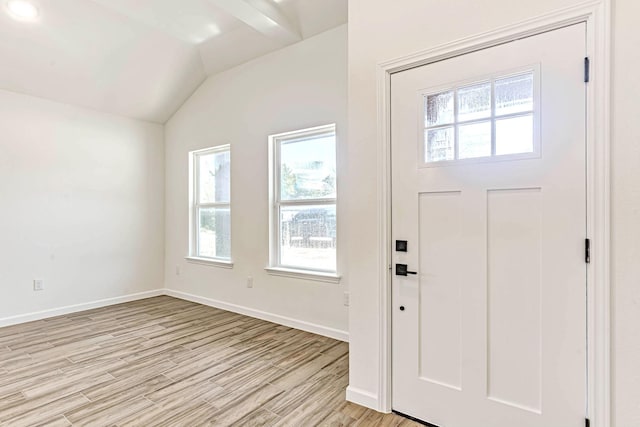 foyer featuring light wood-style floors, vaulted ceiling, a wealth of natural light, and baseboards