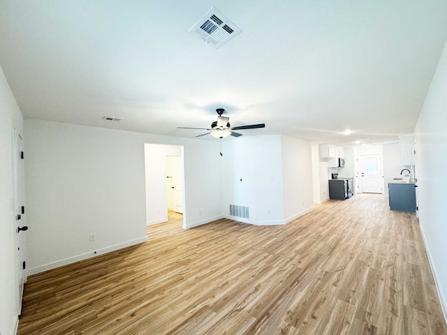 2408 Miller St, Denison, TX 75020 - unfurnished living room featuring baseboards, a ceiling fan, light wood-style floors, and visible vents